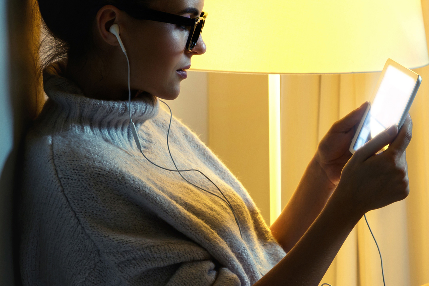 Young woman wearing a warm pullover is using tablet PC