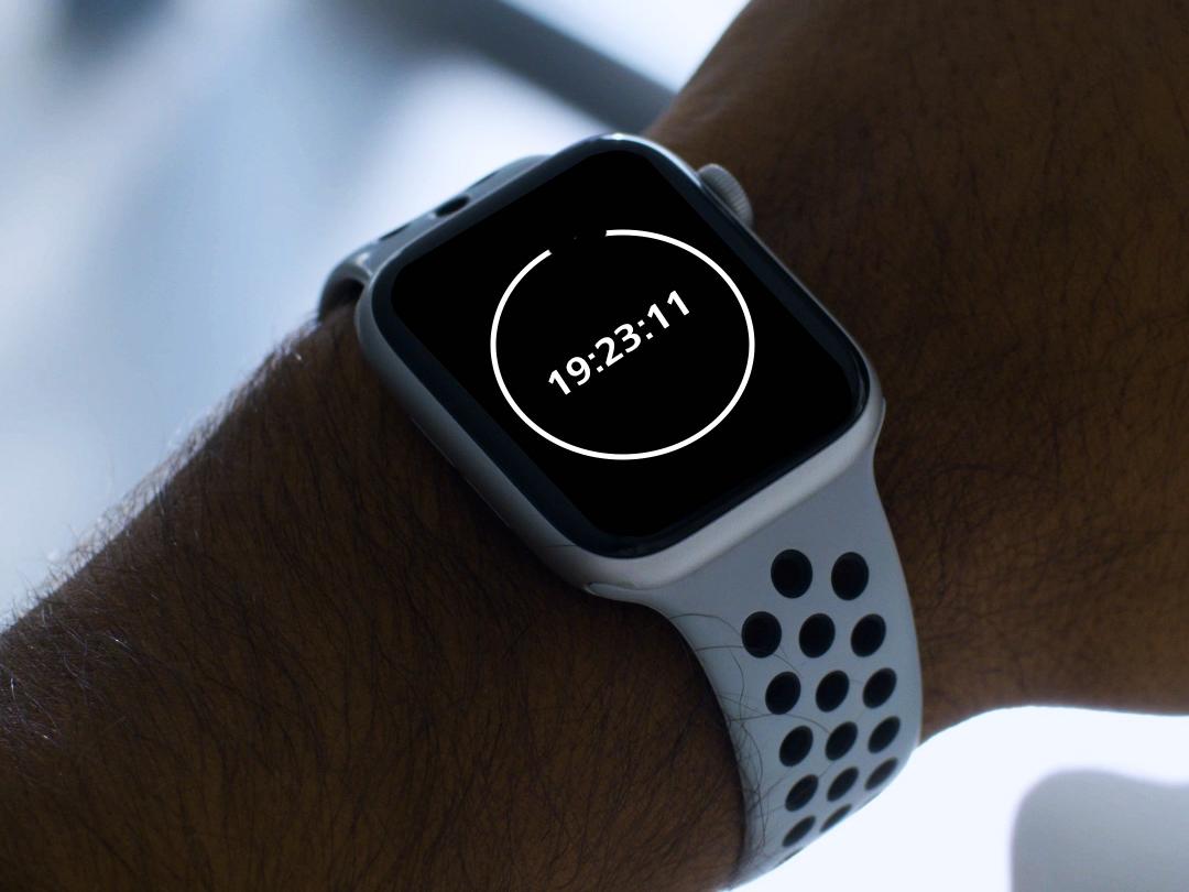 A young man wearing BlueGuard glasses, looking down at his smartwatch showing 20 minute countdown.  