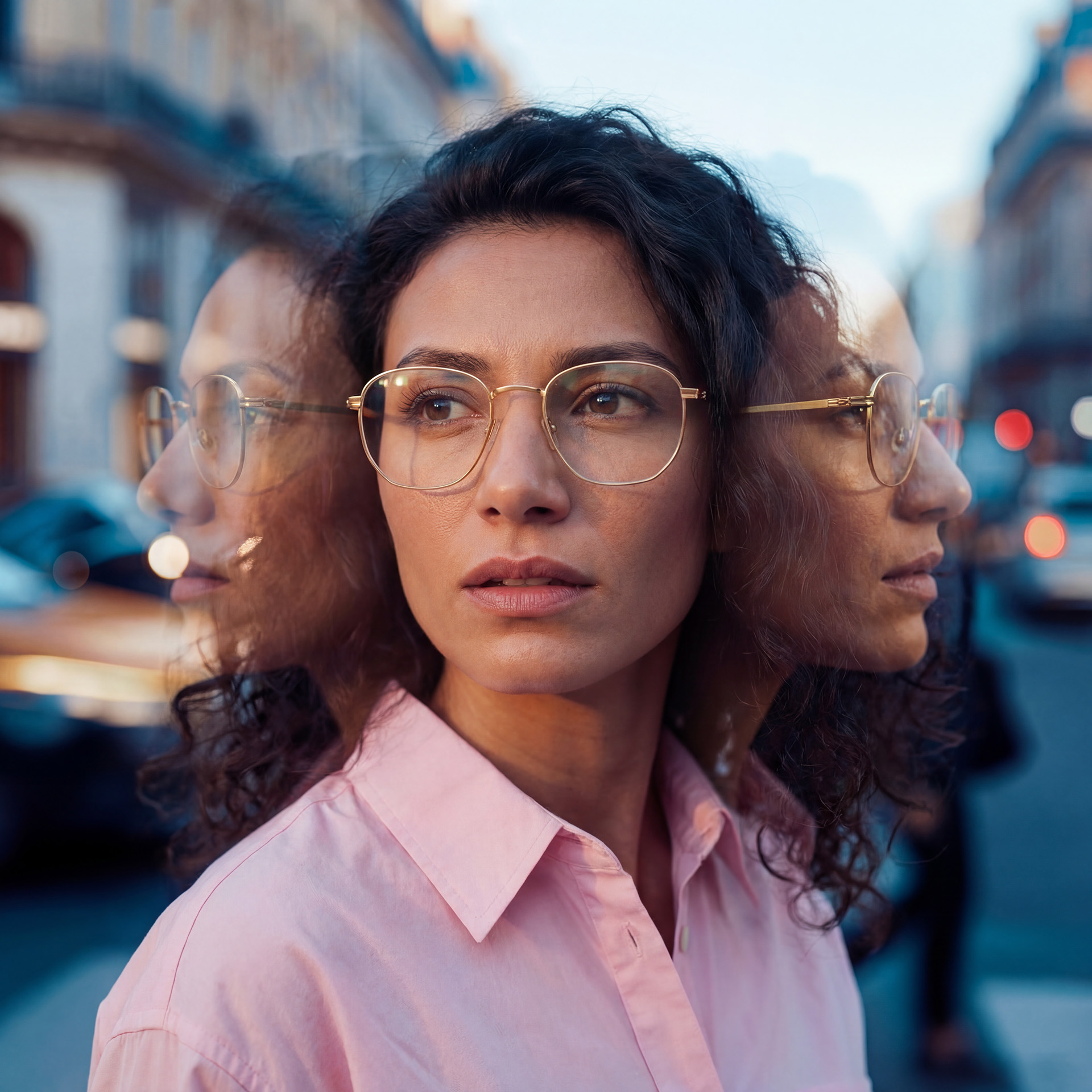 A person wearing conventional eyeglasses on a busy street with multi-exposure effects. 